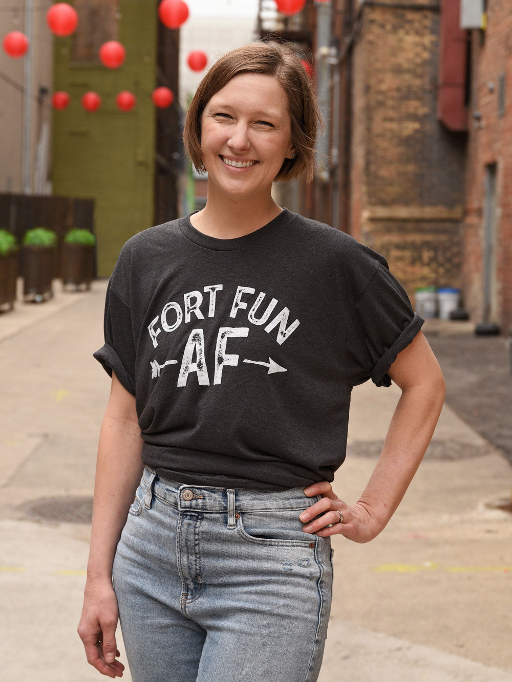 Fort Fun AF t-shirt on model by red paper lanterns