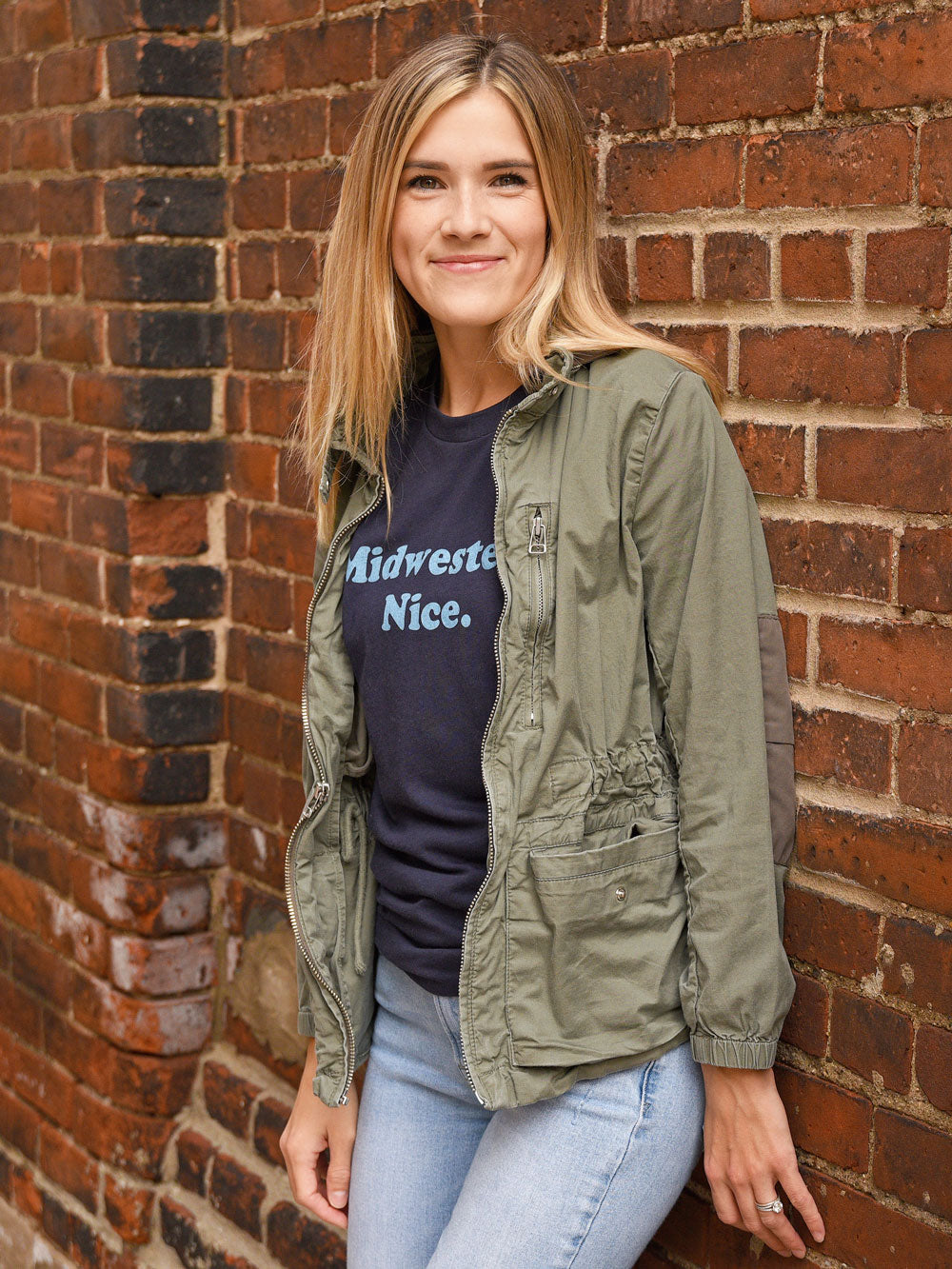 Midwestern Nice navy t-shirt on model by brick wall