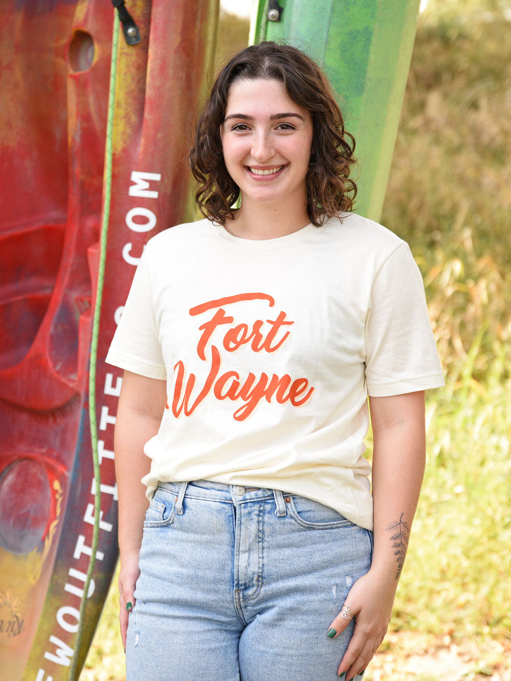 Orange ink Script Fort Wayne t-shirt on model by colorful kayaks