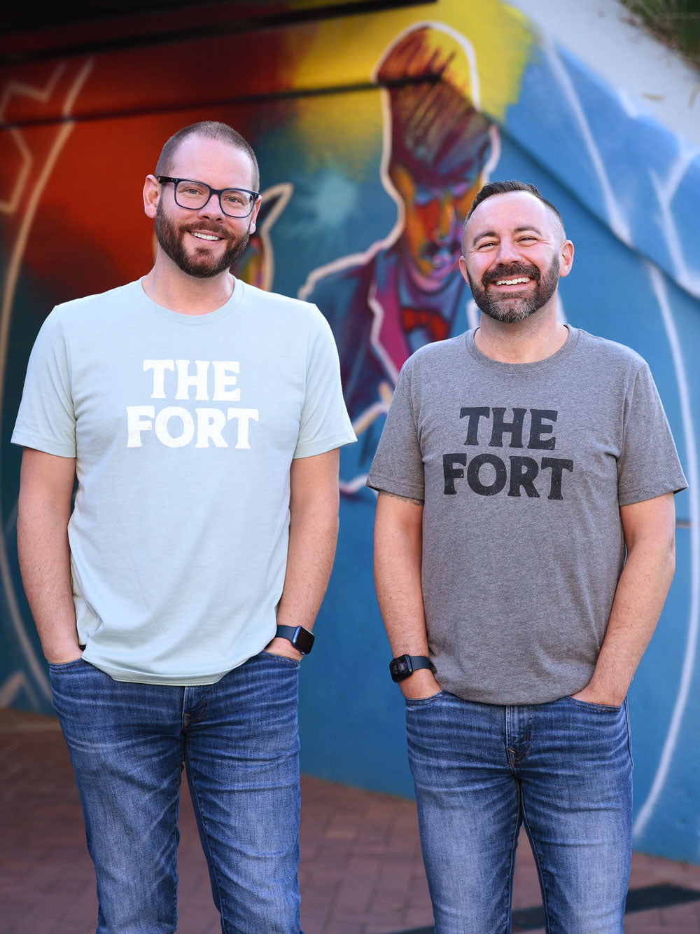 The Fort dusty blue and gray heather t-shirt on models in front of mural