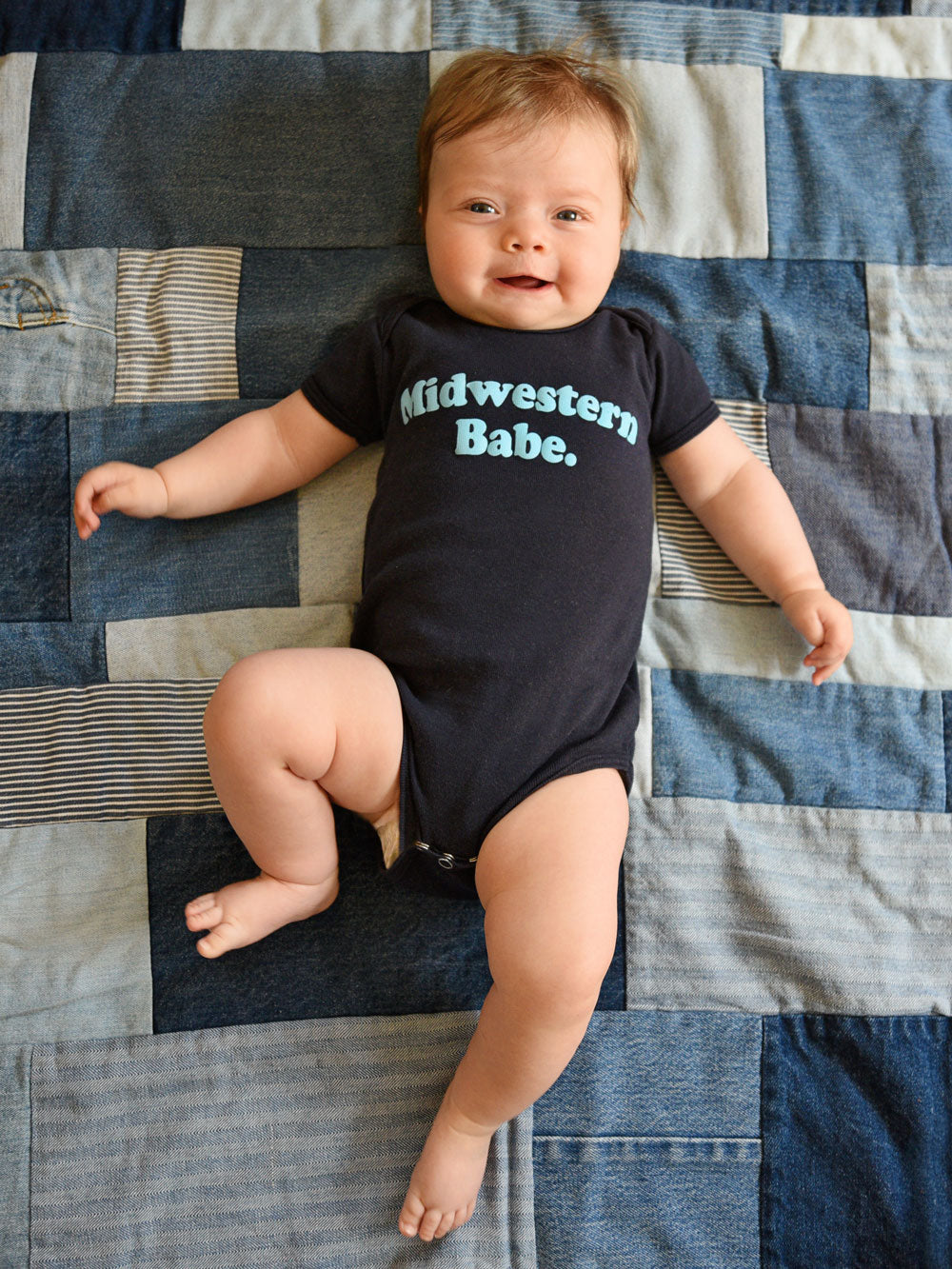 Midwestern Babe navy infant bodysuit on baby on denim quilt