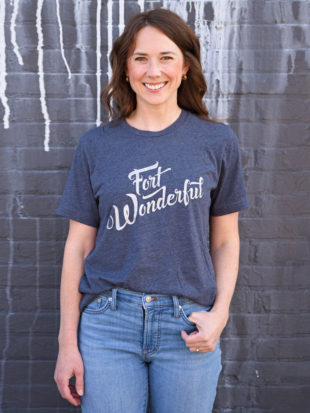 Fort Wonderful navy t-shirt on model in front of black brick wall